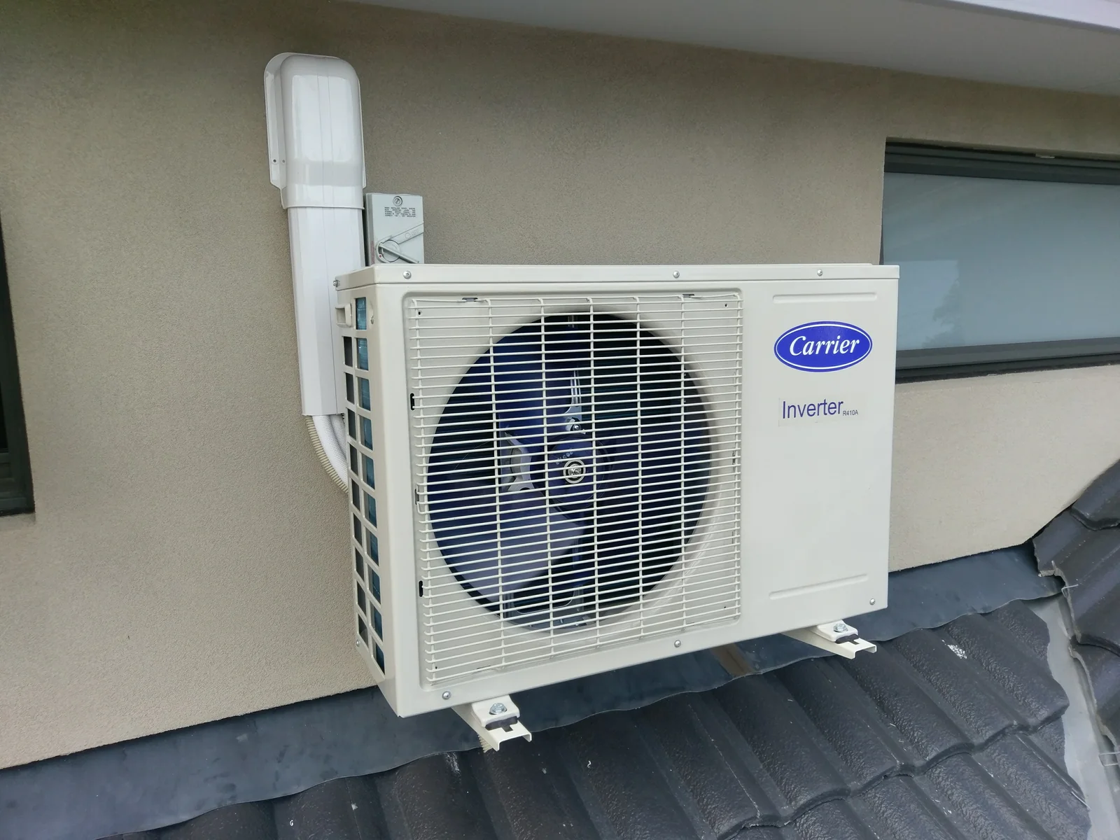 Carrier outdoor unit mounted on a tiled roof