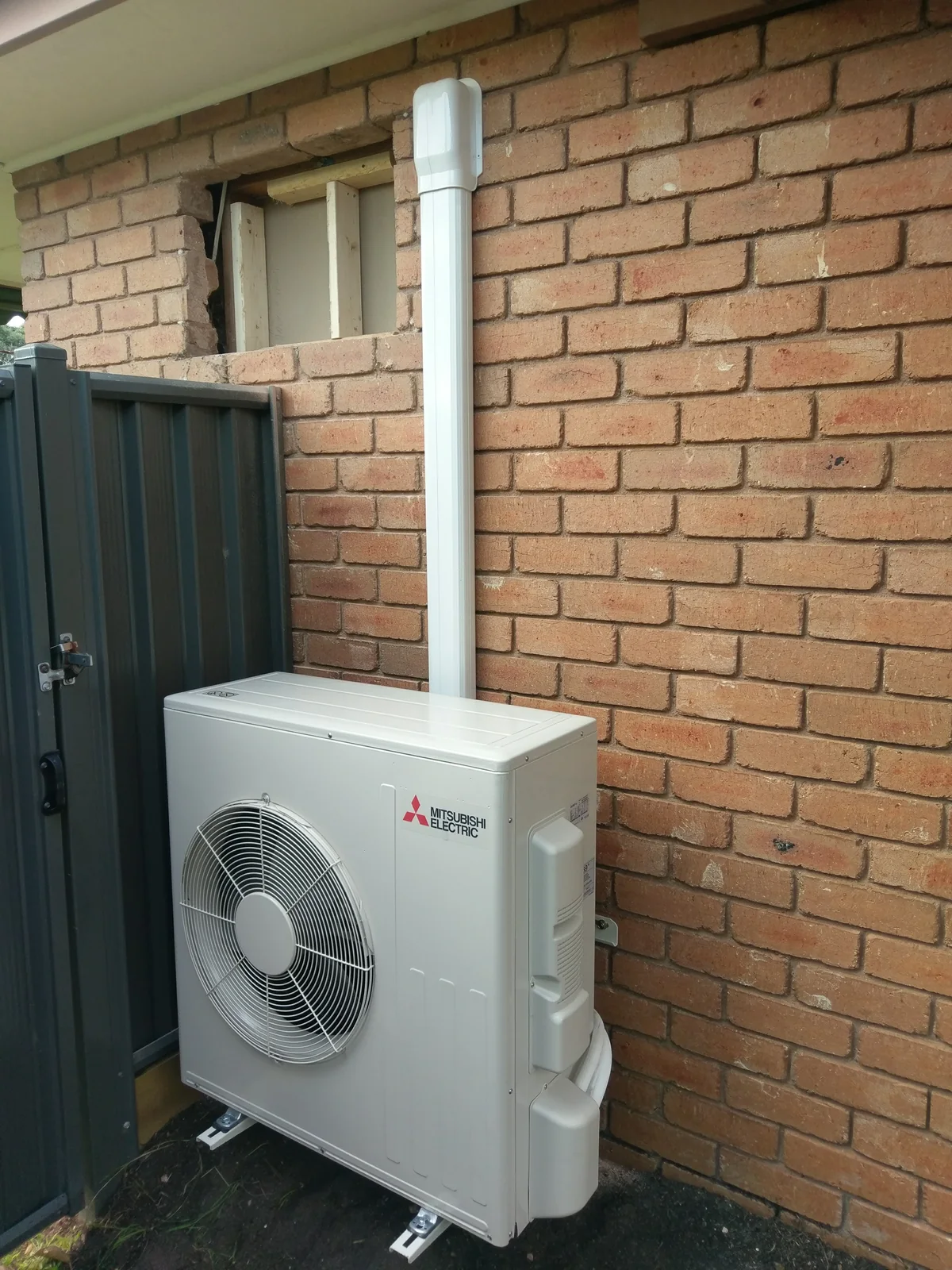 Mitsubishi Electric split system outdoor unit on a brick wall