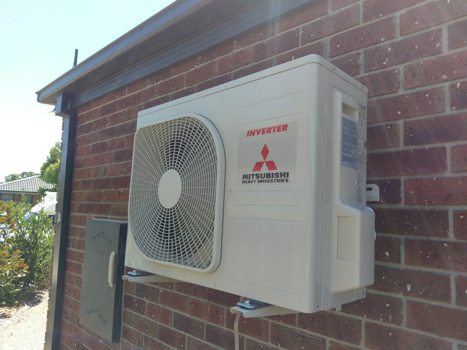 Mitsubishi Electric outdoor unit bracket-mounted high on a brick wall