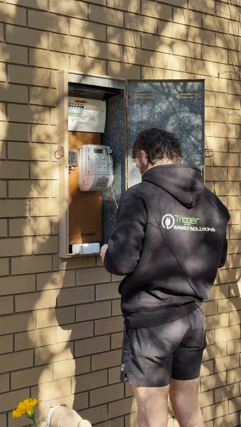 Trigger Energy Solutions electrician working in an open meter box at a Melbourne home, upgrading the switchboard and meter