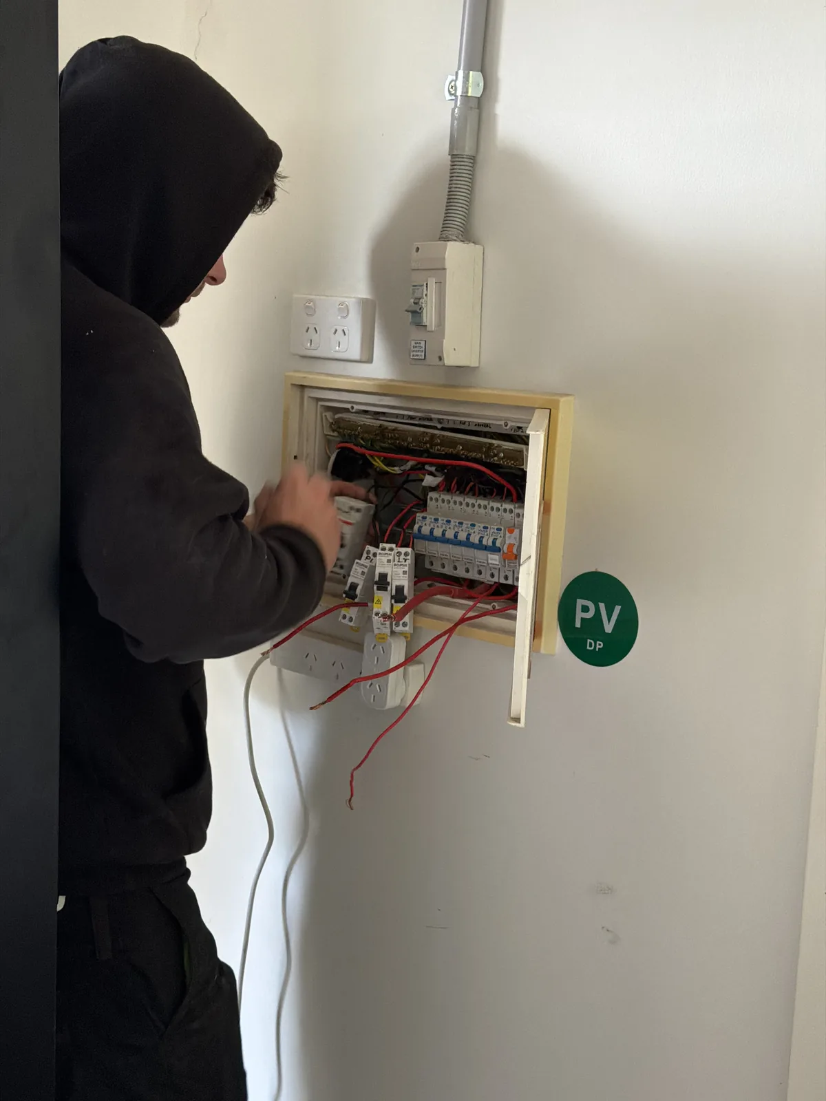 Licensed electrician connecting a solar PV circuit in a switchboard