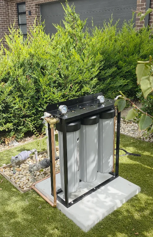 Water filtration system with the cover removed showing three filter cartridges