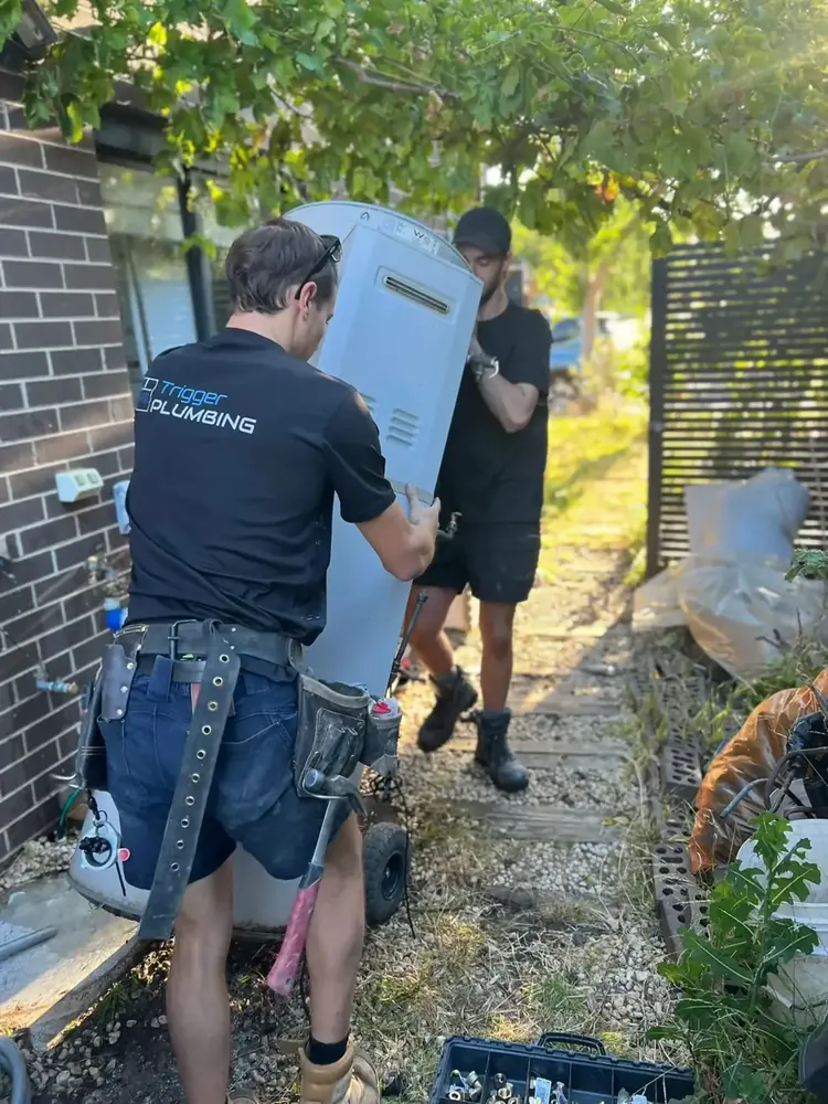 Trigger Group crew positioning an Emerald Energy heat pump