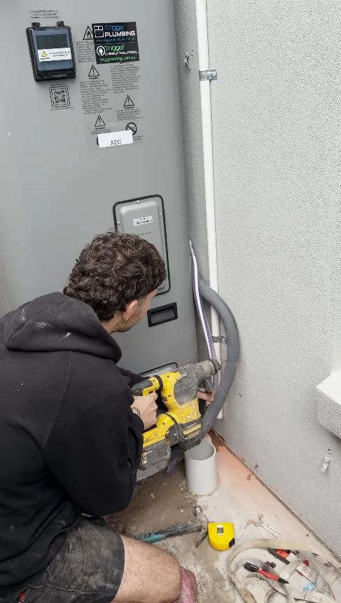 Trigger Plumbing plumber fixing an Emerald heat pump to the slab