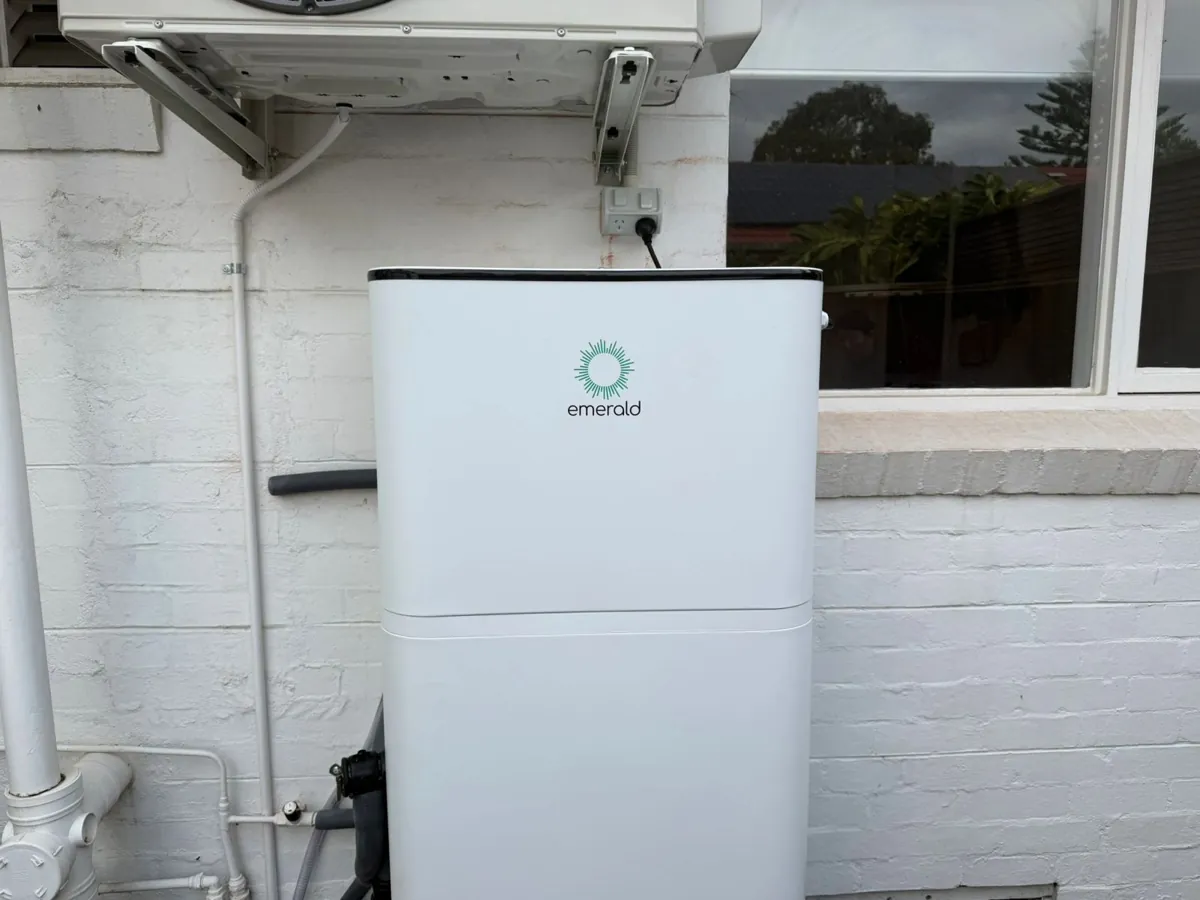 Emerald Energy heat pump against a rendered wall