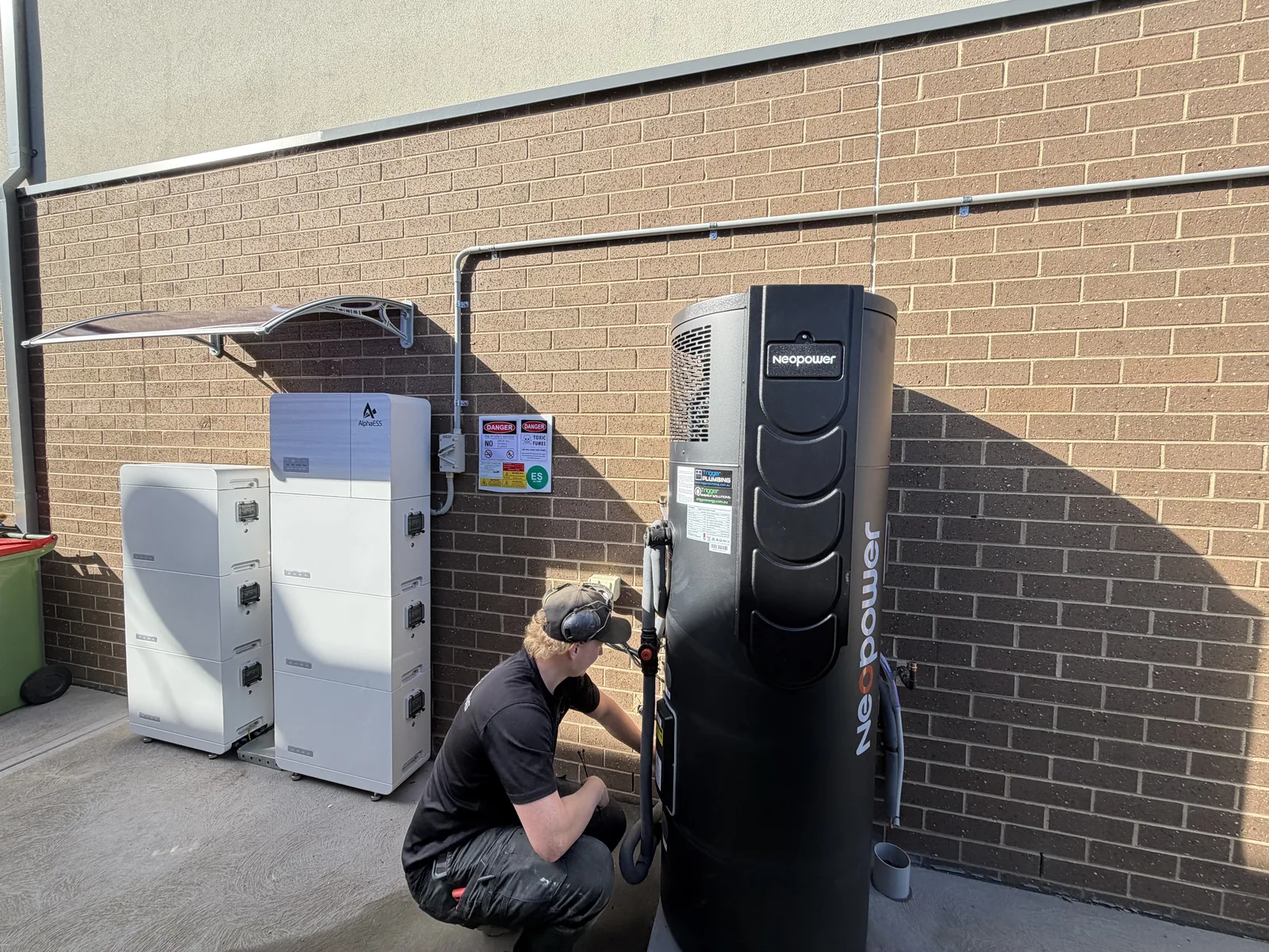 Two Trigger Plumbing crew installing a heat pump